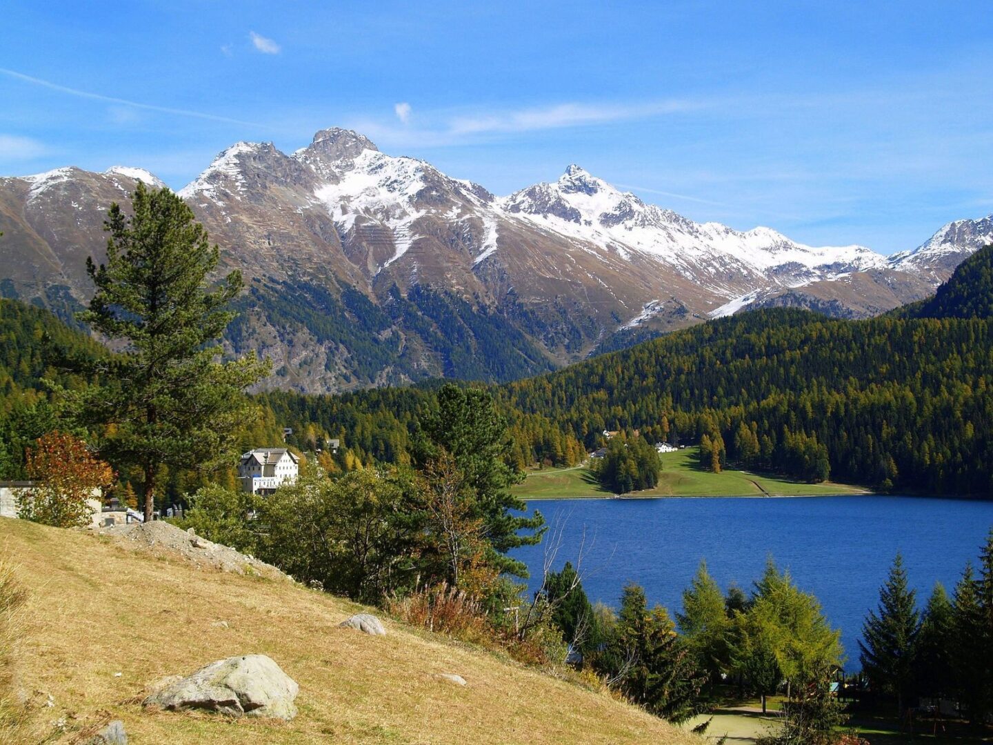 A lake with snow capped mountains in the background.